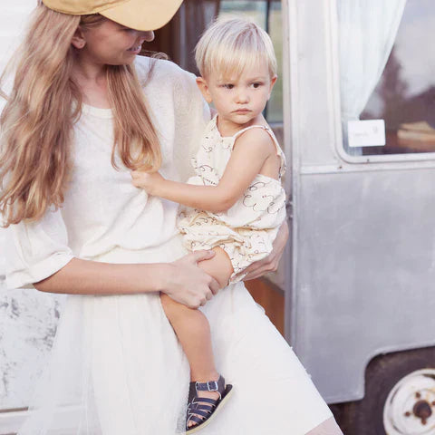 אמא מחזיקה פעוט בסנדלי סולט ווטר לצעד ראשון