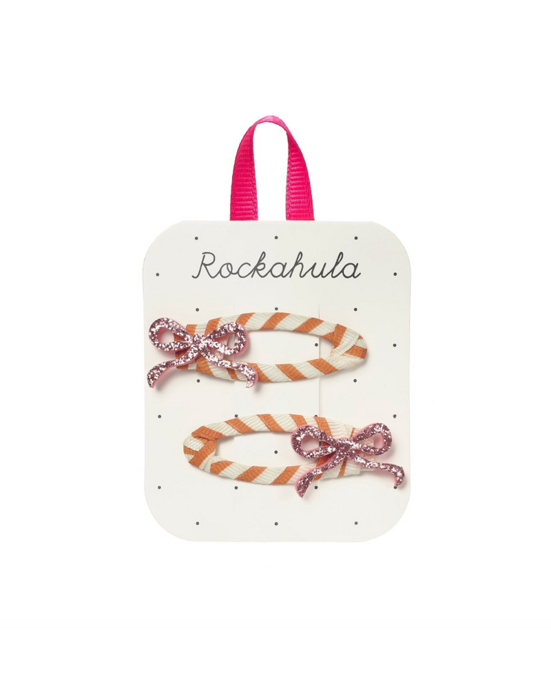 סיכות שיער לילדות עם פפיון ורוד מנצנץ המונח על סרט מפוספס 