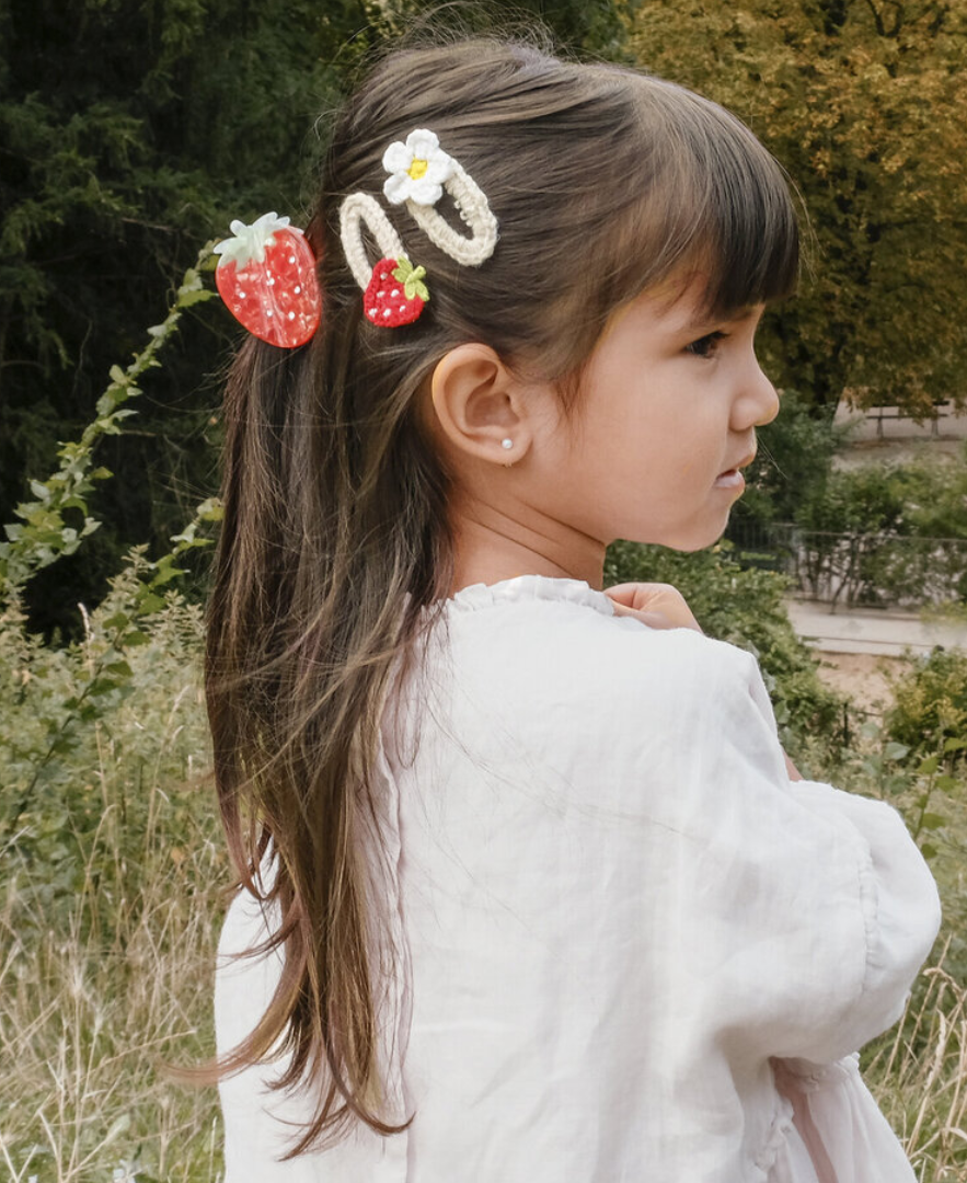 ילדה עם קליפס לשיער תות וסיכות של rockahula kids