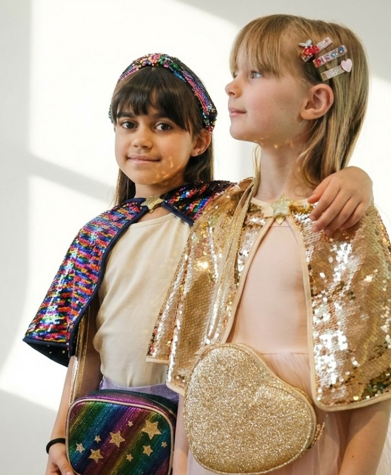 שתי ילדות מתוקות עם אביזרים של רוקוהולה - תיק צד דיסקו ותיק צד לב זהוב מנצנץ. מושלם למתנות!