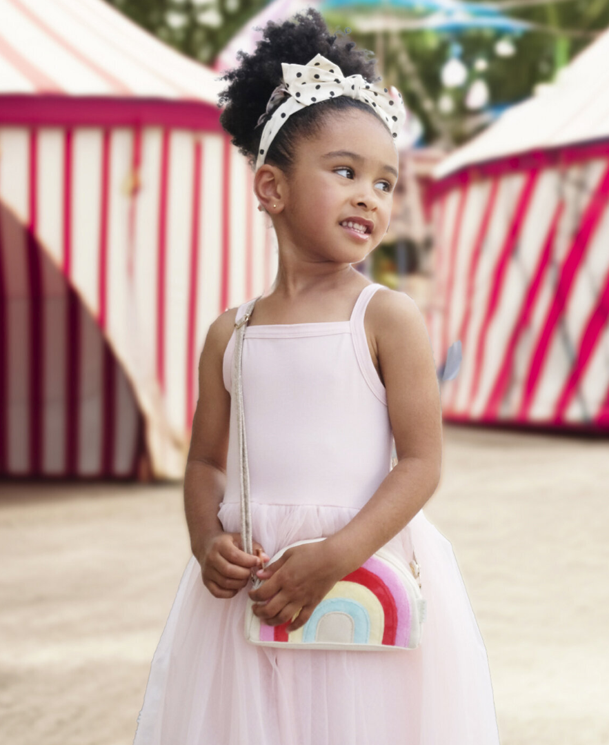 ילדה עם תיק צד בעיצוב קשת בענן צבעונית של rockahula kids