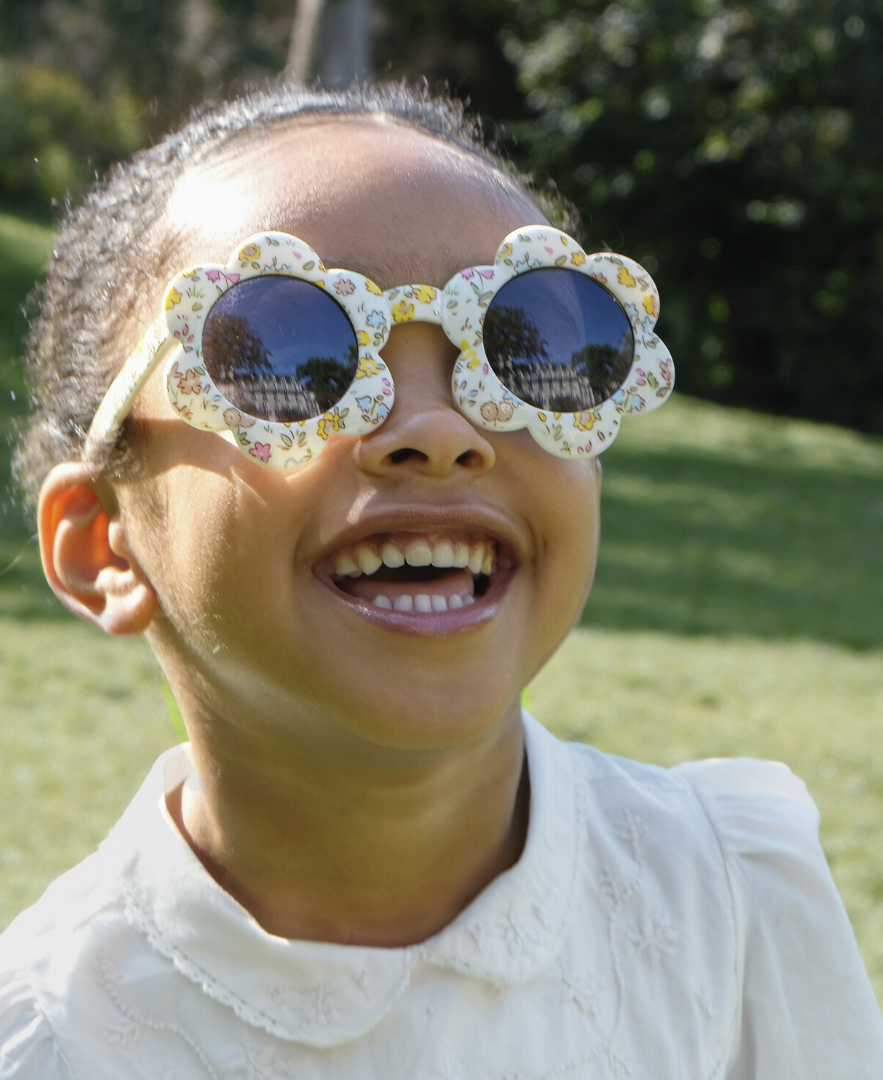 ילדה מחייכת עםמשקפי שמש פרחוניים לילדות